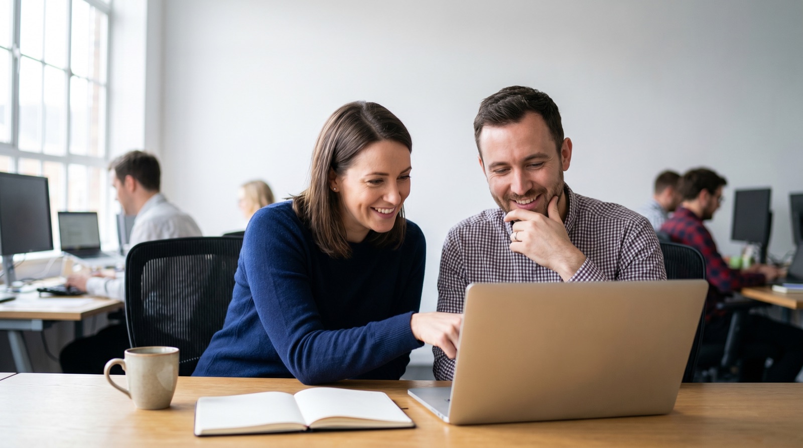 A small marketing team reviewing campaign results together on a laptop in an office